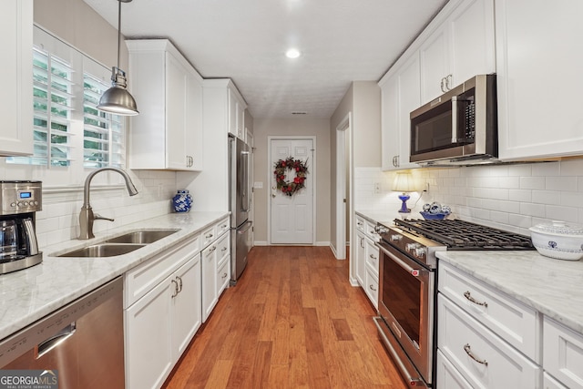 412 Rock Creek Dr, Peachtree City, GA 30269 - kitchen with appliances with stainless steel finishes, a sink, white cabinetry, baseboards, and light wood finished floors