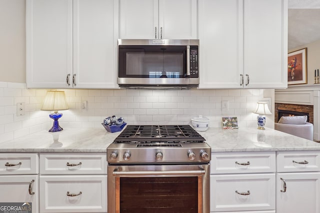 412 Rock Creek Dr, Peachtree City, GA 30269 - kitchen featuring stainless steel appliances, white cabinetry, tasteful backsplash, and light stone counters