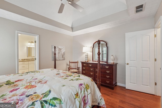 412 Rock Creek Dr, Peachtree City, GA 30269 - bedroom featuring wood finished floors, a tray ceiling, ensuite bath, and a ceiling fan