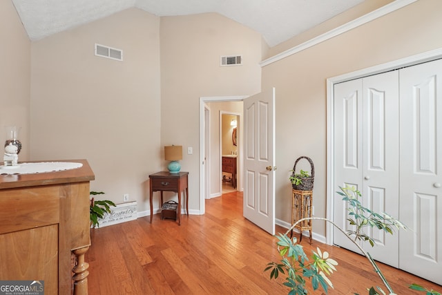 412 Rock Creek Dr, Peachtree City, GA 30269 - living area featuring light wood-style floors, high vaulted ceiling, and baseboards