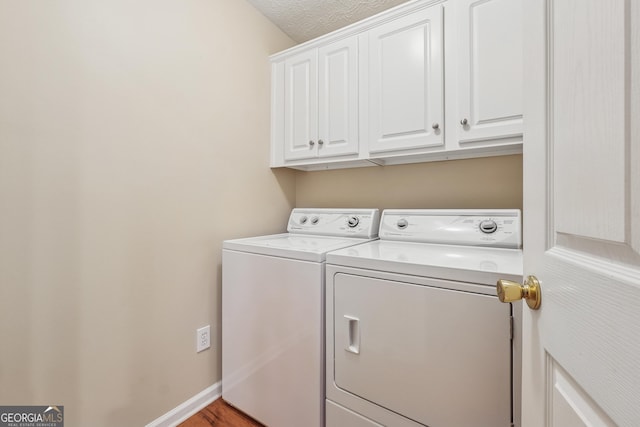 412 Rock Creek Dr, Peachtree City, GA 30269 - laundry area featuring washing machine and clothes dryer, cabinet space, light wood-style flooring, and baseboards