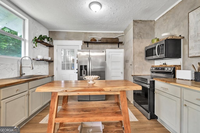 575 E Main St, Buford, GA 30518 - kitchen featuring wood counters, stainless steel appliances, a sink, open shelves, and light wood-style flooring