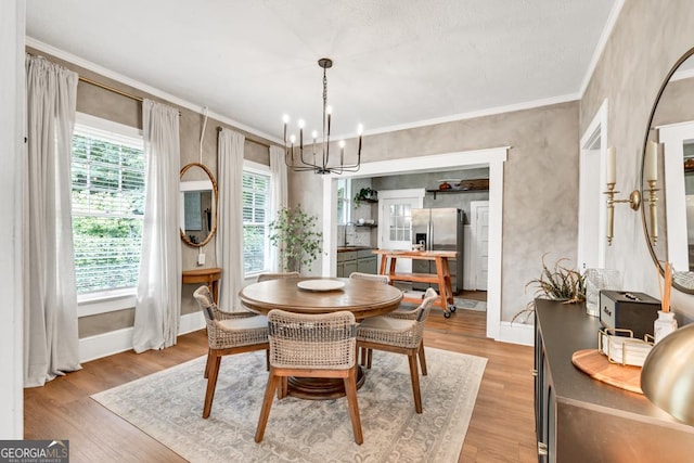 575 E Main St, Buford, GA 30518 - dining area with a chandelier, light wood-style floors, crown molding, and baseboards