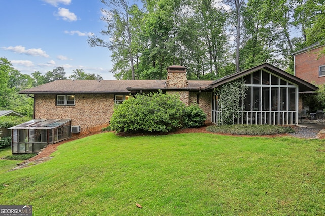 2700 Regency Dr E, Tucker, GA 30084 - rear view of house with a sunroom, brick siding, a greenhouse, and a lawn