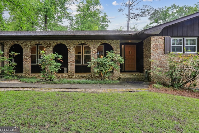 2700 Regency Dr E, Tucker, GA 30084 - view of front of property with a front lawn, board and batten siding, brick siding, and covered porch