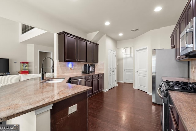 4965 Brierstone Dr, Alpharetta, GA 30004 - kitchen with a sink, stainless steel appliances, dark brown cabinets, dark wood-style flooring, and tasteful backsplash