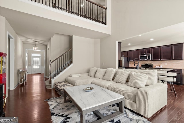 4965 Brierstone Dr, Alpharetta, GA 30004 - living area with dark wood finished floors, a high ceiling, stairs, and recessed lighting