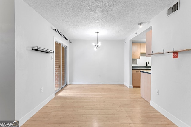 387 Ralph Mcgill Blvd NE Unit K, Atlanta, GA 30312 - unfurnished dining area featuring a textured ceiling, light wood finished floors, and a chandelier