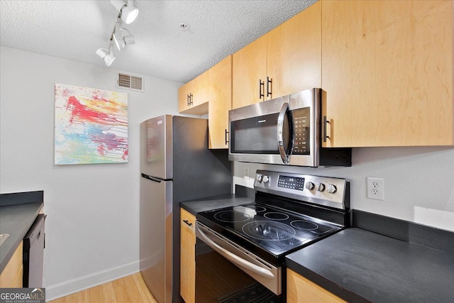 387 Ralph Mcgill Blvd NE Unit K, Atlanta, GA 30312 - kitchen with stainless steel appliances, light brown cabinets, dark countertops, a textured ceiling, and light wood-style floors