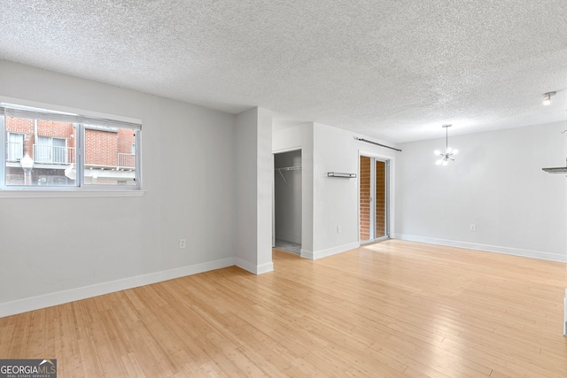 387 Ralph Mcgill Blvd NE Unit K, Atlanta, GA 30312 - unfurnished room featuring a chandelier, light wood-style floors, and a textured ceiling