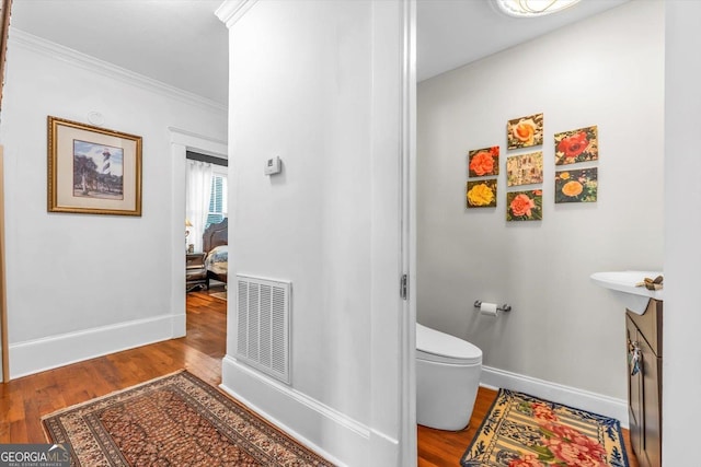 403 E Robert Toombs Ave, Washington, GA 30673 - bathroom with toilet, wood finished floors, baseboards, and ornamental molding