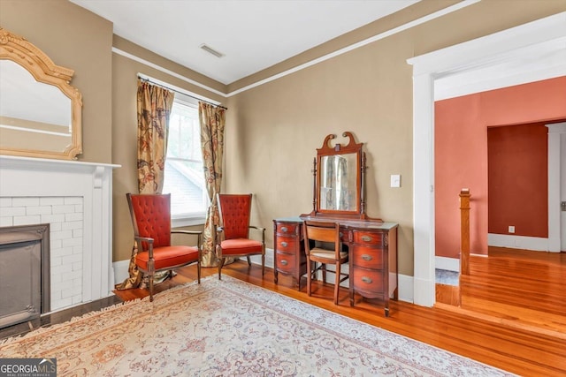 403 E Robert Toombs Ave, Washington, GA 30673 - sitting room featuring wood finished floors, baseboards, and a brick fireplace