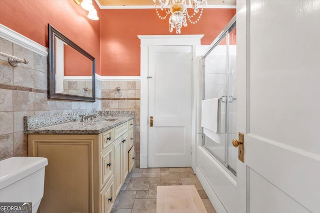 403 E Robert Toombs Ave, Washington, GA 30673 - bathroom featuring tile walls, vanity, toilet, a chandelier, and enclosed tub / shower combo