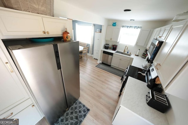 531 Beaver Pond Rd, Carrollton, GA 30117 - kitchen featuring stainless steel appliances, light wood-style flooring, white cabinets, and light countertops