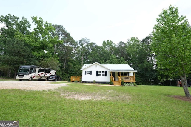 531 Beaver Pond Rd, Carrollton, GA 30117 - view of front of property with covered porch, a front lawn, and view of wooded area