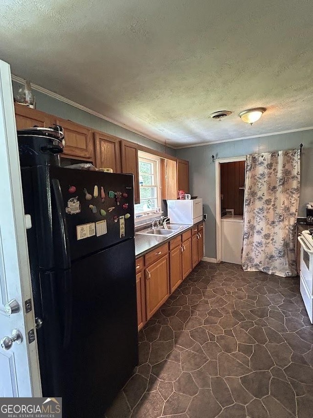 260 W Teamon Cir, Griffin, GA 30223 - kitchen featuring freestanding refrigerator, a textured ceiling, brown cabinetry, a sink, and crown molding