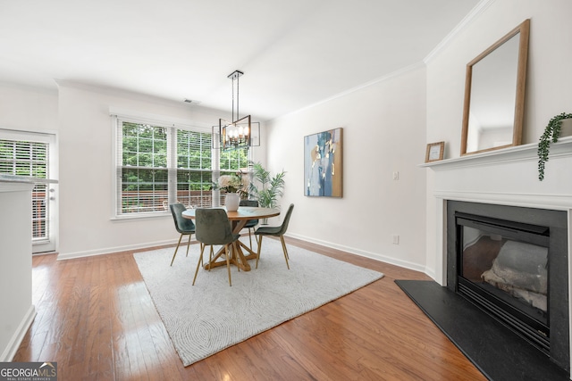 3655 Chattahoochee Summit Dr SE Unit 16, Atlanta, GA 30339 - dining area featuring crown molding, wood finished floors, a chandelier, a glass covered fireplace, and baseboards