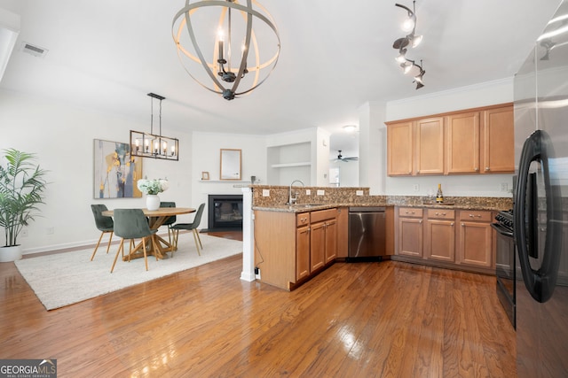 3655 Chattahoochee Summit Dr SE Unit 16, Atlanta, GA 30339 - kitchen with stainless steel appliances, a sink, a chandelier, wood finished floors, and a peninsula