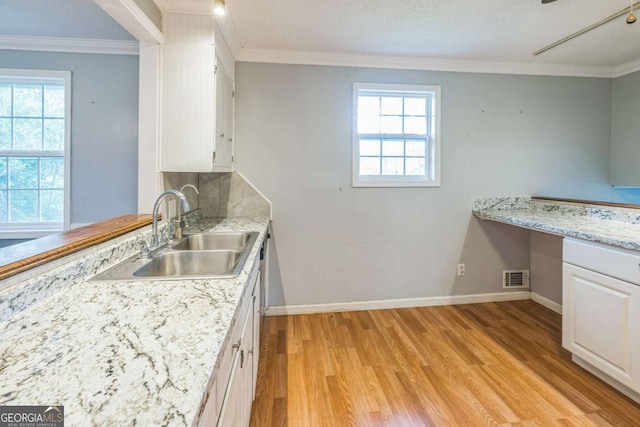 4572 Colonial Rd, Augusta, GA 30907 - kitchen with light wood finished floors, white cabinetry, crown molding, and light stone counters