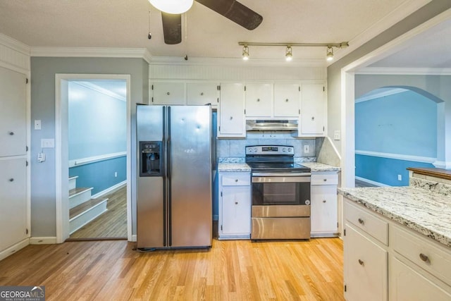 4572 Colonial Rd, Augusta, GA 30907 - kitchen with appliances with stainless steel finishes, under cabinet range hood, arched walkways, white cabinets, and light wood-style flooring