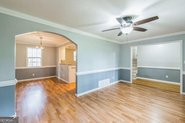 4572 Colonial Rd, Augusta, GA 30907 - spare room with a ceiling fan, wood finished floors, arched walkways, ornamental molding, and a chandelier