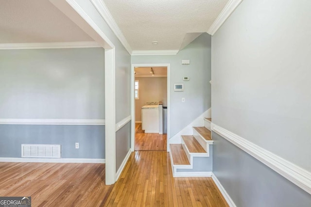 4572 Colonial Rd, Augusta, GA 30907 - hallway with hardwood / wood-style floors, a textured ceiling, stairway, and crown molding