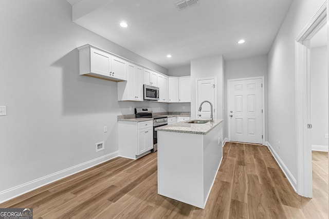 211 Lenox Cir, Lagrange, GA 30241 - kitchen featuring stainless steel appliances, a sink, white cabinets, light wood-style floors, and recessed lighting