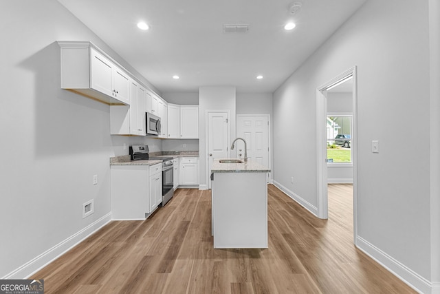 211 Lenox Cir, Lagrange, GA 30241 - kitchen featuring stainless steel appliances, a sink, baseboards, light wood-type flooring, and white cabinets