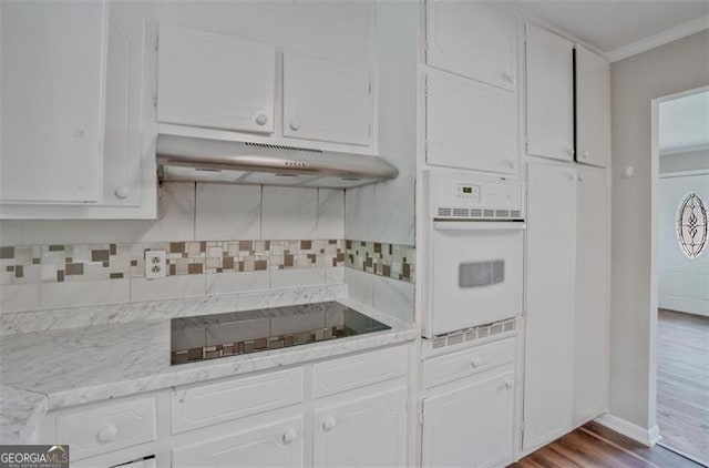 622 Sheffield Rd, Norcross, GA 30071 - kitchen featuring white oven, under cabinet range hood, black electric cooktop, white cabinets, and ornamental molding