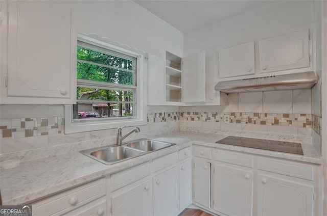 622 Sheffield Rd, Norcross, GA 30071 - kitchen with under cabinet range hood, a sink, black electric stovetop, white cabinets, and light countertops