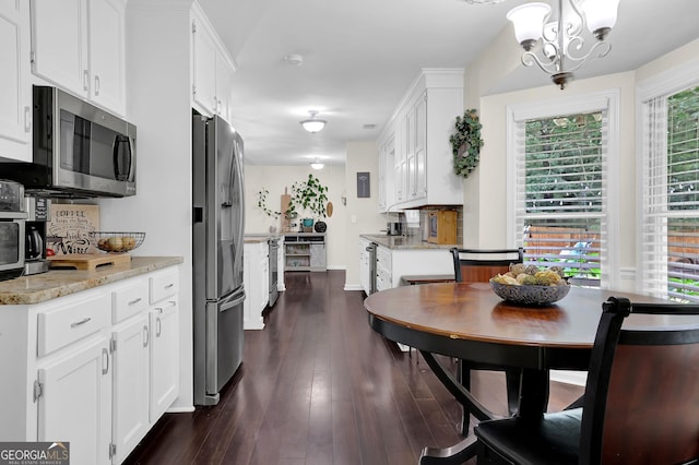 4180 Gables Pl, Buford, GA 30519 - kitchen featuring stainless steel appliances, a chandelier, dark wood finished floors, and white cabinets