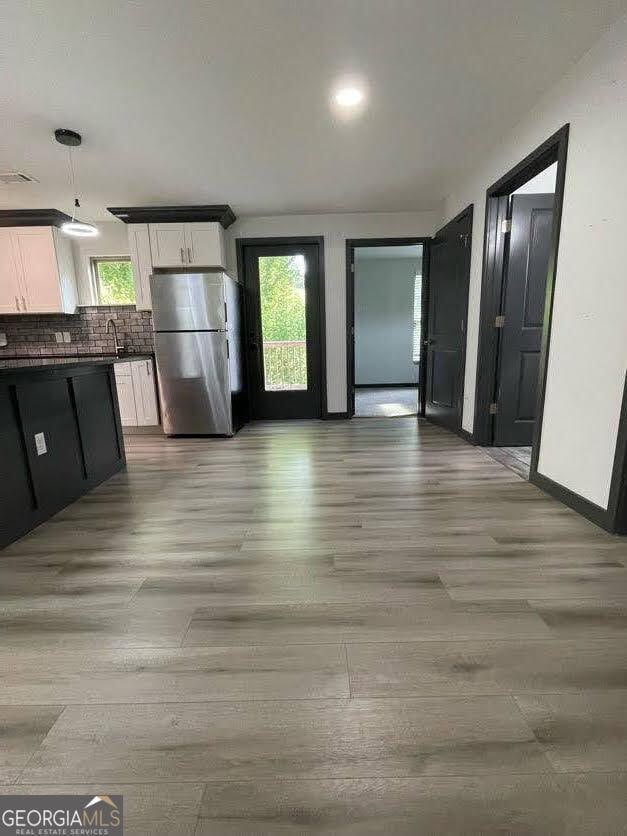 185 Glenrose Cir SW, Atlanta, GA 30354 - kitchen with freestanding refrigerator, dark countertops, white cabinetry, and light wood-style flooring