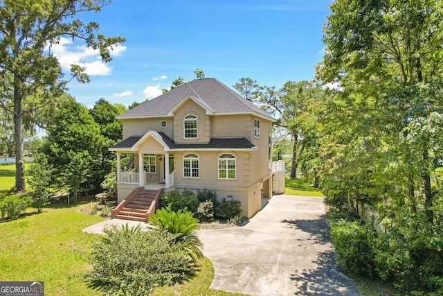 515 Youmans Rd, Midway, GA 31320 - view of front of house featuring concrete driveway, a shingled roof, a porch, stucco siding, and a front yard