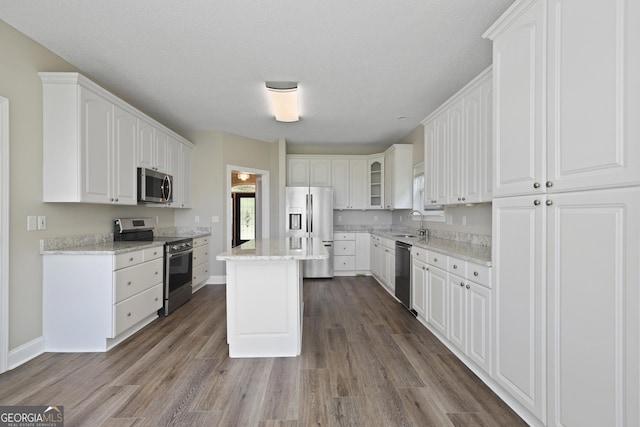 515 Youmans Rd, Midway, GA 31320 - kitchen with appliances with stainless steel finishes, a sink, dark wood-type flooring, white cabinetry, and light stone counters