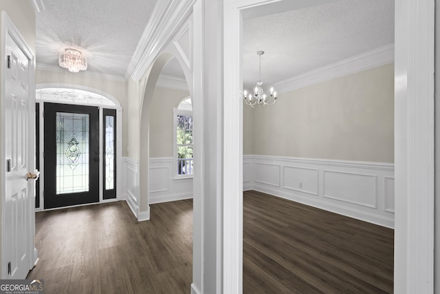 515 Youmans Rd, Midway, GA 31320 - foyer featuring a chandelier, dark wood-style flooring, a textured ceiling, wainscoting, and arched walkways