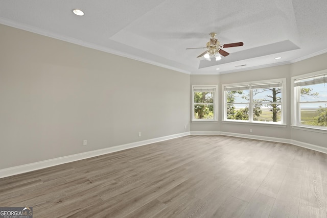 515 Youmans Rd, Midway, GA 31320 - empty room with a raised ceiling, a ceiling fan, wood finished floors, baseboards, and crown molding