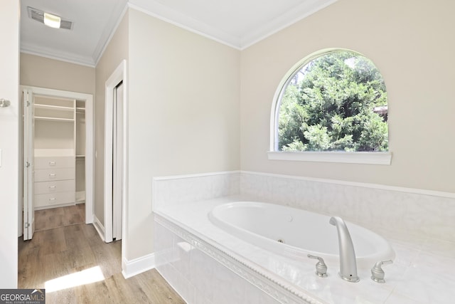 515 Youmans Rd, Midway, GA 31320 - bathroom with a tub with jets, crown molding, wood finished floors, and a walk in closet