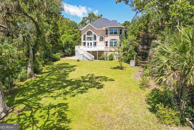 515 Youmans Rd, Midway, GA 31320 - rear view of property with stairs, stucco siding, and a yard