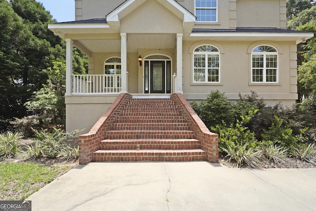 515 Youmans Rd, Midway, GA 31320 - view of exterior entry with stucco siding and a porch