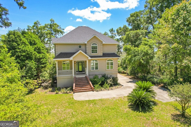 515 Youmans Rd, Midway, GA 31320 - traditional-style house featuring stairs, a shingled roof, a front lawn, a porch, and stucco siding