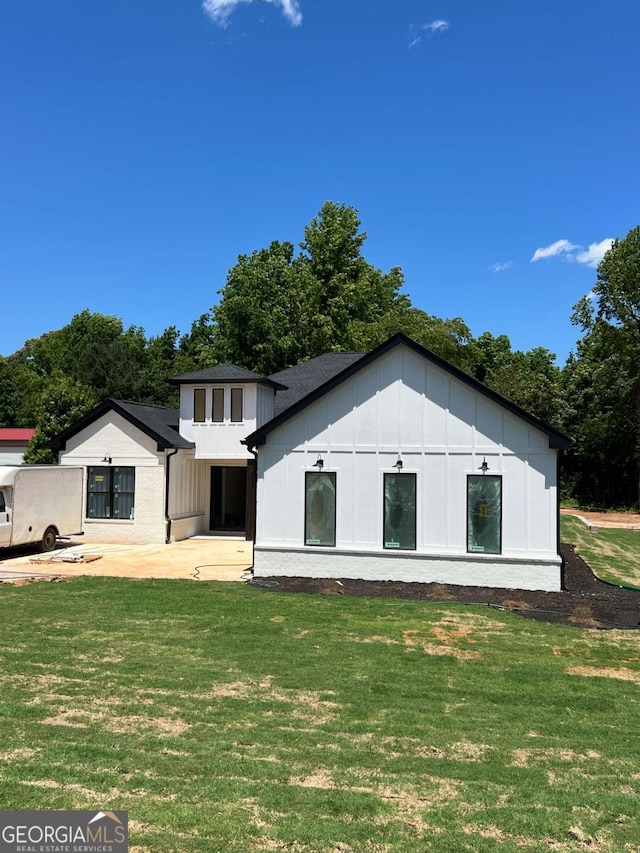 520 SW Rockbridge Rd SW, Lilburn, GA 30047 - back of property featuring board and batten siding, a yard, and a patio