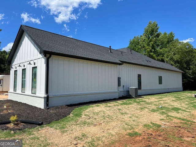 520 SW Rockbridge Rd SW, Lilburn, GA 30047 - view of property exterior featuring roof with shingles, a lawn, and board and batten siding