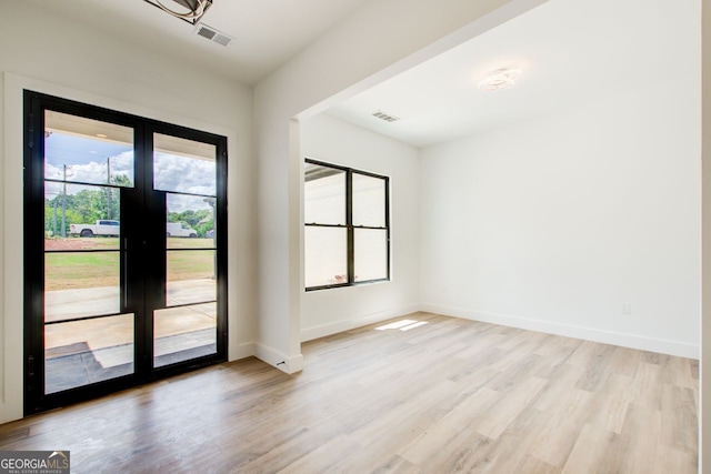 520 SW Rockbridge Rd SW, Lilburn, GA 30047 - empty room with french doors and light wood-style flooring