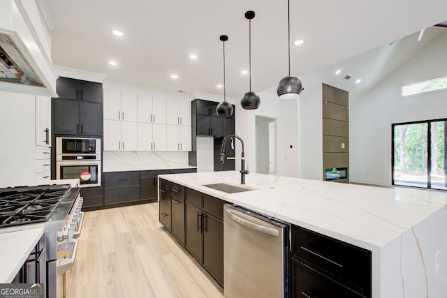 520 SW Rockbridge Rd SW, Lilburn, GA 30047 - kitchen with stainless steel appliances, custom range hood, light wood finished floors, an island with sink, and backsplash