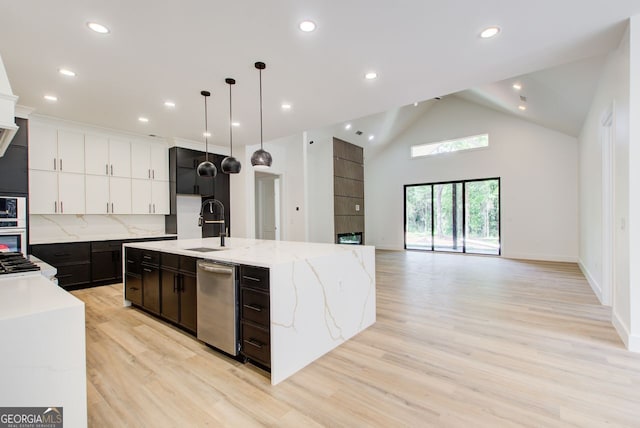 520 SW Rockbridge Rd SW, Lilburn, GA 30047 - kitchen featuring appliances with stainless steel finishes, light wood finished floors, an island with sink, recessed lighting, and hanging light fixtures