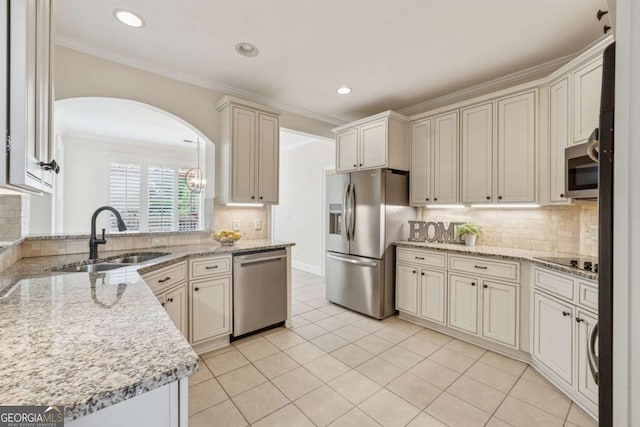 3743 Lake Edge Dr, Suwanee, GA 30024 - kitchen featuring stainless steel appliances, a sink, ornamental molding, decorative backsplash, and light stone countertops