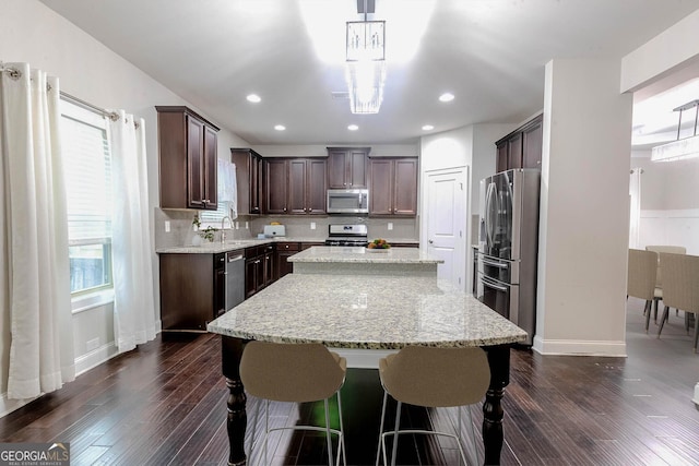3758 Lake Haven Way, Atlanta, GA 30349 - kitchen with appliances with stainless steel finishes, a center island, dark brown cabinetry, dark wood finished floors, and a sink