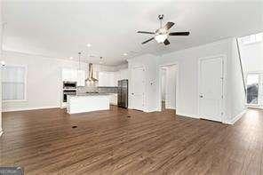 5924 Mitchell St, Flowery Branch, GA 30542 - unfurnished living room with dark wood-style flooring and ceiling fan