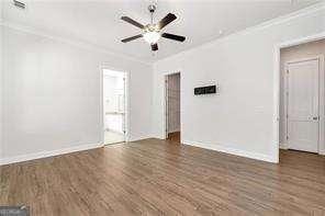 5924 Mitchell St, Flowery Branch, GA 30542 - empty room with ornamental molding, baseboards, wood finished floors, and ceiling fan