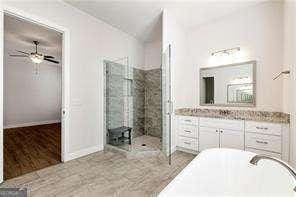 5924 Mitchell St, Flowery Branch, GA 30542 - bathroom featuring a freestanding tub, vanity, ceiling fan, and a tile shower